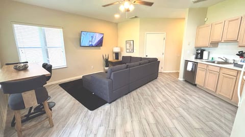 Open living and dining space with updated flooring, cozy seating, and a bright kitchen layout.