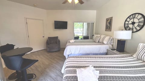 Spacious bedroom with two comfortable beds, TV, sitting area, and a clean, welcoming setup.