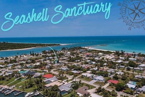 Aerial view of Seashell Sanctuary near the water, highlighting the coastal location and surrounding neighborhood.
