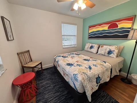 Cozy bedroom with beach-inspired decor, comfortable bed, and warm natural light.