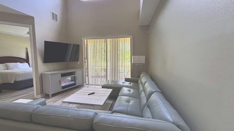 Relax in comfort with this sleek, oversized sectional sofa facing a contemporary media console with an integrated electric fireplace. Large sliding doors lead directly out to the sunny patio.