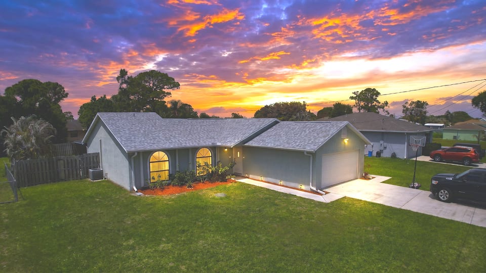 Beautiful exterior view of the home at sunset with a welcoming front yard and attached garage.
