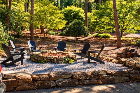 Hand-crafted stone defines the landscape: a fire pit built to last, sky arcing above, ready for long nights of talking and flames.
