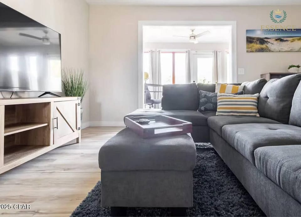 the living room with wide sofa and huge tv