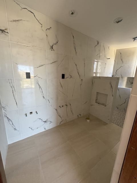 Modern marble-look bathroom with sleek tilework and built-in shower niches