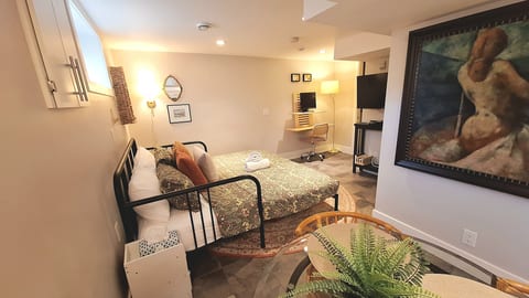 Cozy bedroom suite with workspace, TV, and charming dining nook