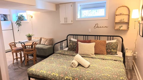 Cozy studio retreat with charming decor, dining nook, and inviting bed