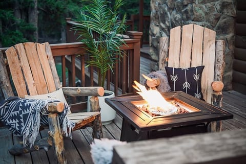 Enjoy forest views on our tranquil patio with a fire pit and string lights