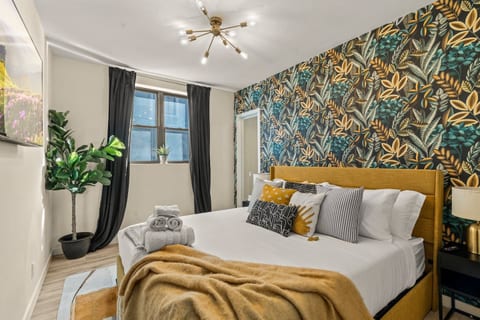 Embrace the warmth of this stylish bedroom! Featuring a vibrant botanical wallpaper and elegant furnishings, it invites relaxation. Curl up with a blanket and enjoy the serene ambiance, creating a perfect haven for restful nights.