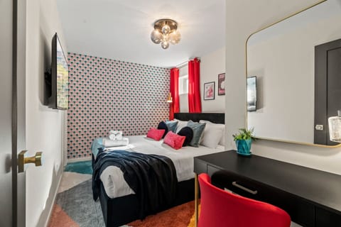 This cozy bedroom radiates comfort! The bright yellow headboard adds a cheerful pop, while decorative pillows enhance relaxation. With plush towels neatly rolled, this inviting space makes every guest feel right at home and ready for a restful stay.