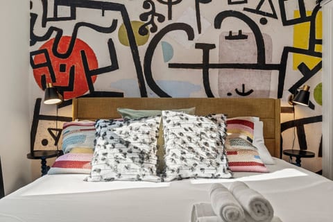 Wake up surrounded by bold, artistic vibes! The comfy bed and textured pillows make this a perfect, chic retreat to recharge.