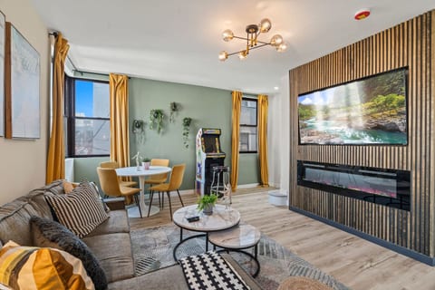 Cozy up for a movie night! This inviting living room features a sleek fireplace and large-screen TV. Perfect for relaxing after a day of exploring the city.
