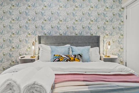 Crisp linens, layered hues, and golden light create a space that feels both soothing and sophisticated.