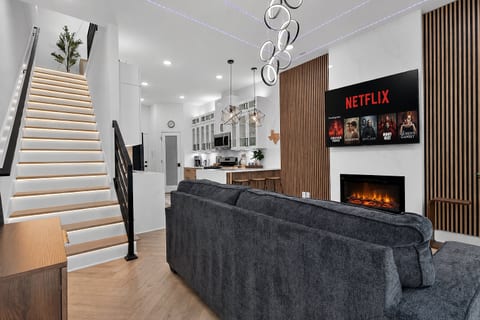 Stylish open lounge with LED stairs, fireplace, and smart TV for movie nights