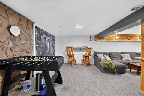 Cozy game room with foosball, sectional seating, and rustic charm