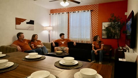 Cozy open living space with large sectional, dining table, and TV