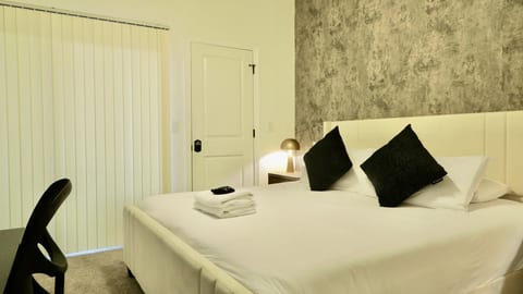 Modern cozy bedroom with plush bed, soft lighting, and stylish accents