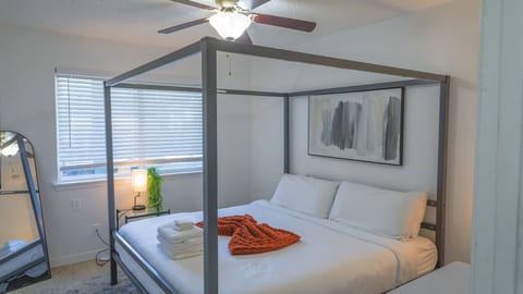 Bright modern bedroom with four-poster bed and cozy designer touches