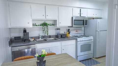 Bright full kitchen with dining nook, gas stove, and coffee station