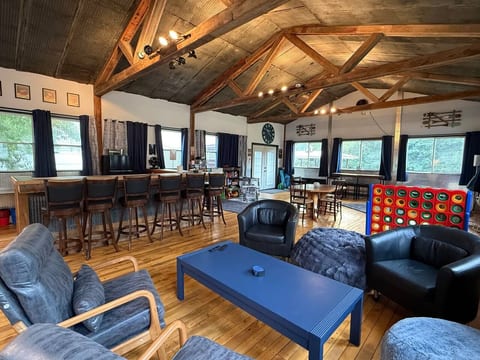 Spacious rustic great room with bar seating, vaulted beams, and game area