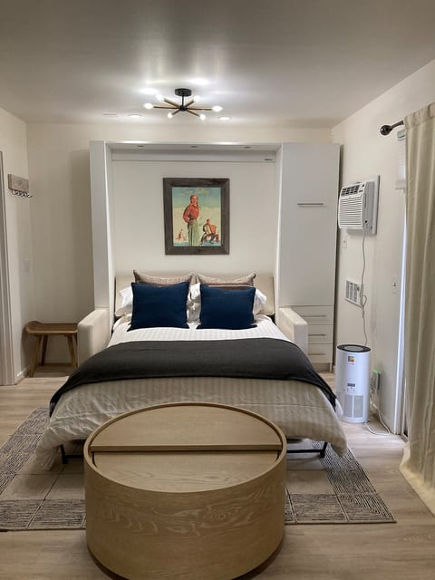 Murphy bed with pull out table in one side and ample storage.