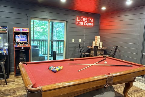 Game room with pool table, arcade games, and cozy cabin vibes