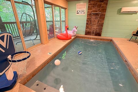 Private indoor plunge pool with forest views, floats, and fun games