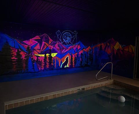 Indoor pool with vibrant neon mural for a one-of-a-kind retreat