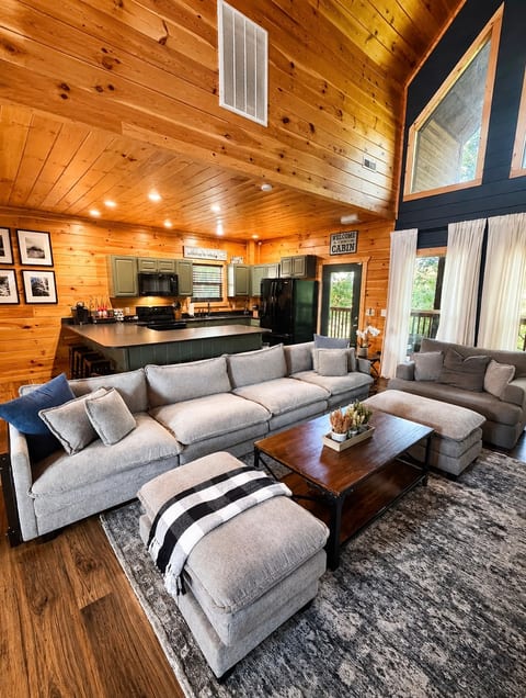Cozy open-concept cabin with vaulted ceilings, big sectional, and full kitchen