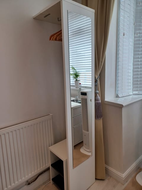 Full-length mirror, open wardrobe and wooden hangers provided