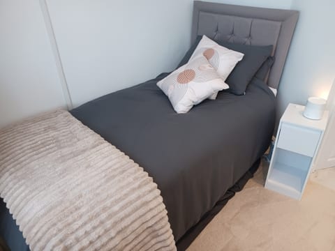 Premium grey linen, faux fur throw and decorative cushions on your single bed