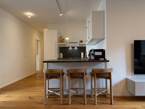 Modern white kitchen with breakfast bar and warm wood accents