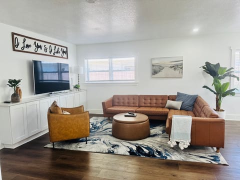 Bright modern living room with leather sectional and large TV