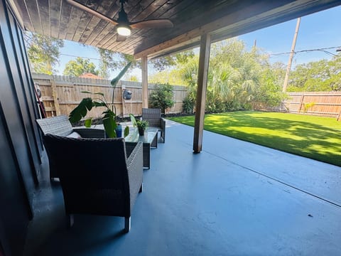 Covered patio with comfy seating and a private, lush fenced yard