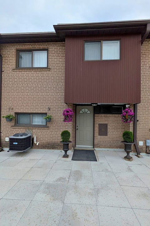 Welcoming townhouse entry with private door and charming floral accents
