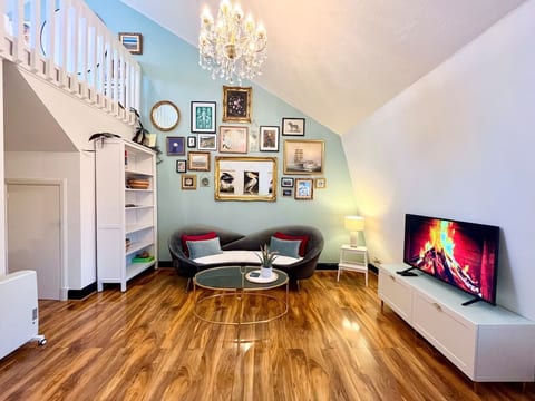 Velvet chaise with feather cushions, Glass oval and gold table, bookshelves, drawers, Sony Bravia Smart TV, Framed paintings and prints, dimmable crystal chandelier.