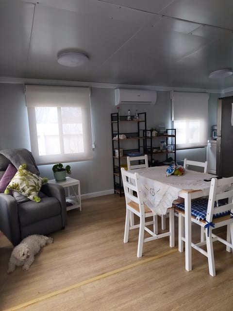 Relax in the open dining area featuring a table with 4 chairs, a comfortable recliner, and a TV for your entertainment.