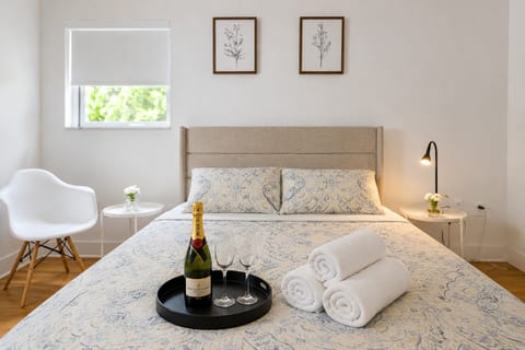 Serene Retreat: Modern bed with plush linens, crisp decor, and a touch of elegance awaits you!