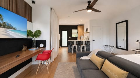 Studio Retreat: Stylish living area with modern decor, bright lighting, and a view of beach bliss!