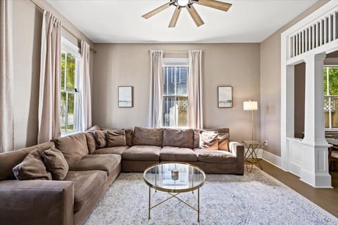 The heart of the Manor. Our spacious 1886 living area features a plush sectional and streaming sunlight—perfect for cozy movie nights, lively social gatherings, and relaxing after a day exploring The Strand and Galveston beaches.