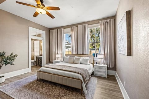 A peaceful 1886 retreat. This elegant primary suite features a plush king bed, high ceilings, and oversized windows that bathe the room in natural light—offering a serene sanctuary after a day of Galveston sun and sand.