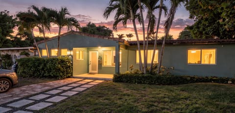 Tropical sunset retreat with glowing interiors and inviting curb appeal