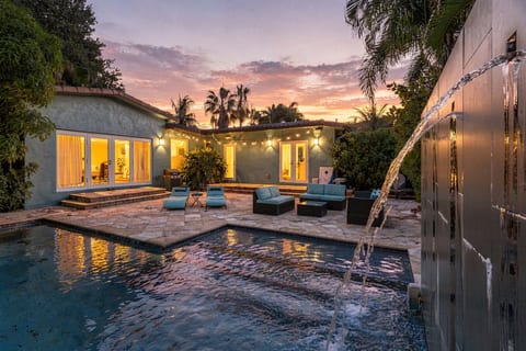 Private sunset pool oasis with water features and stylish patio seating