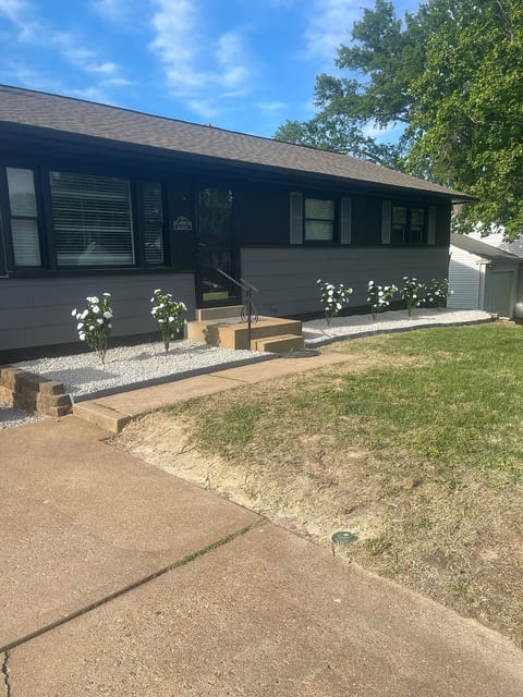 This fully remodeled home boasts a modern two-tone exterior with fresh paint, black shutters, and crisp landscaping. The front yard features a clean gravel bed with blooming white flowers and a welcoming concrete entry. A private, fenced in yard.