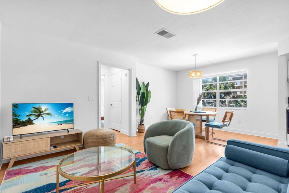 Main living room with ample seating, dining today and bright sunshine gracing the windows.