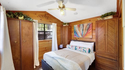 Cozy bedroom featuring warm wood walls and subtle jungle accents.
