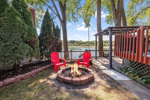 Enjoy cozy evenings around the fire pit with scenic lake views in the background, perfect for relaxing and unwinding outdoors.