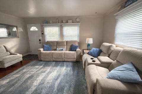 Living Room with Smart TV and two reclining couches and a chair.  There are also two side tables.