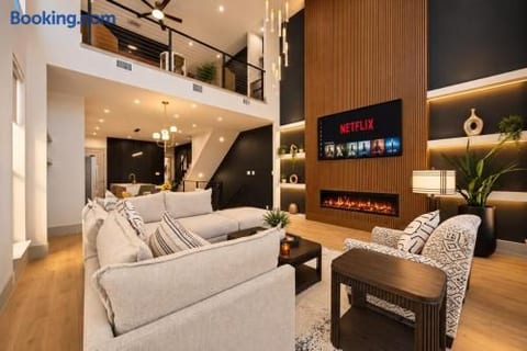 Soaring modern living room with fireplace, loft, and designer style