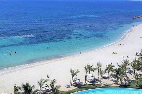 Vista aérea de la playa, con palmera que producen un sonido relajante, con sus aguas cristalinas que se puede observar el fondo, Playa a 5 minutos de distancia del edificio a pie y 3 en carro